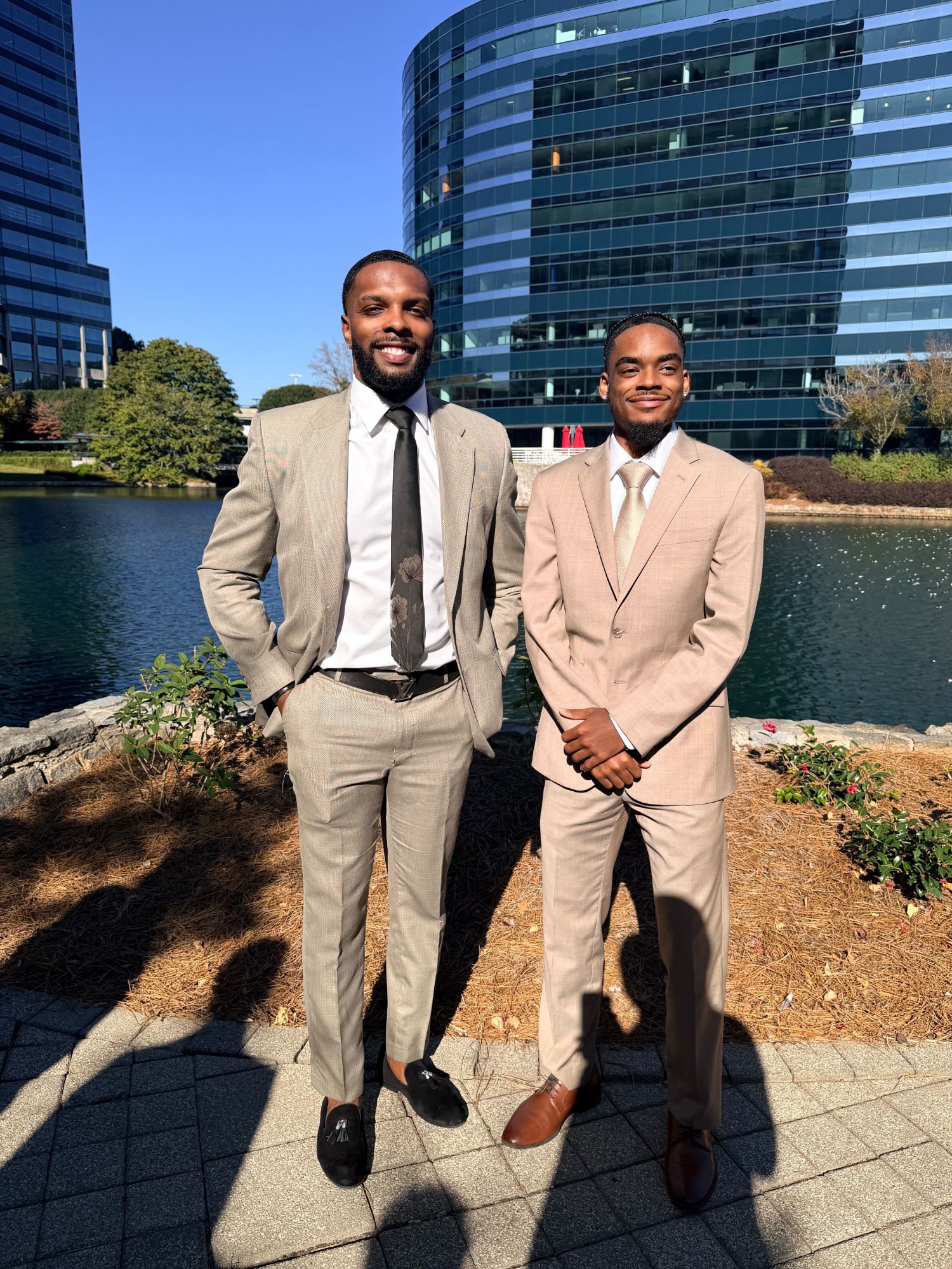 Team member in a stylish green plaid suit in front of glass building