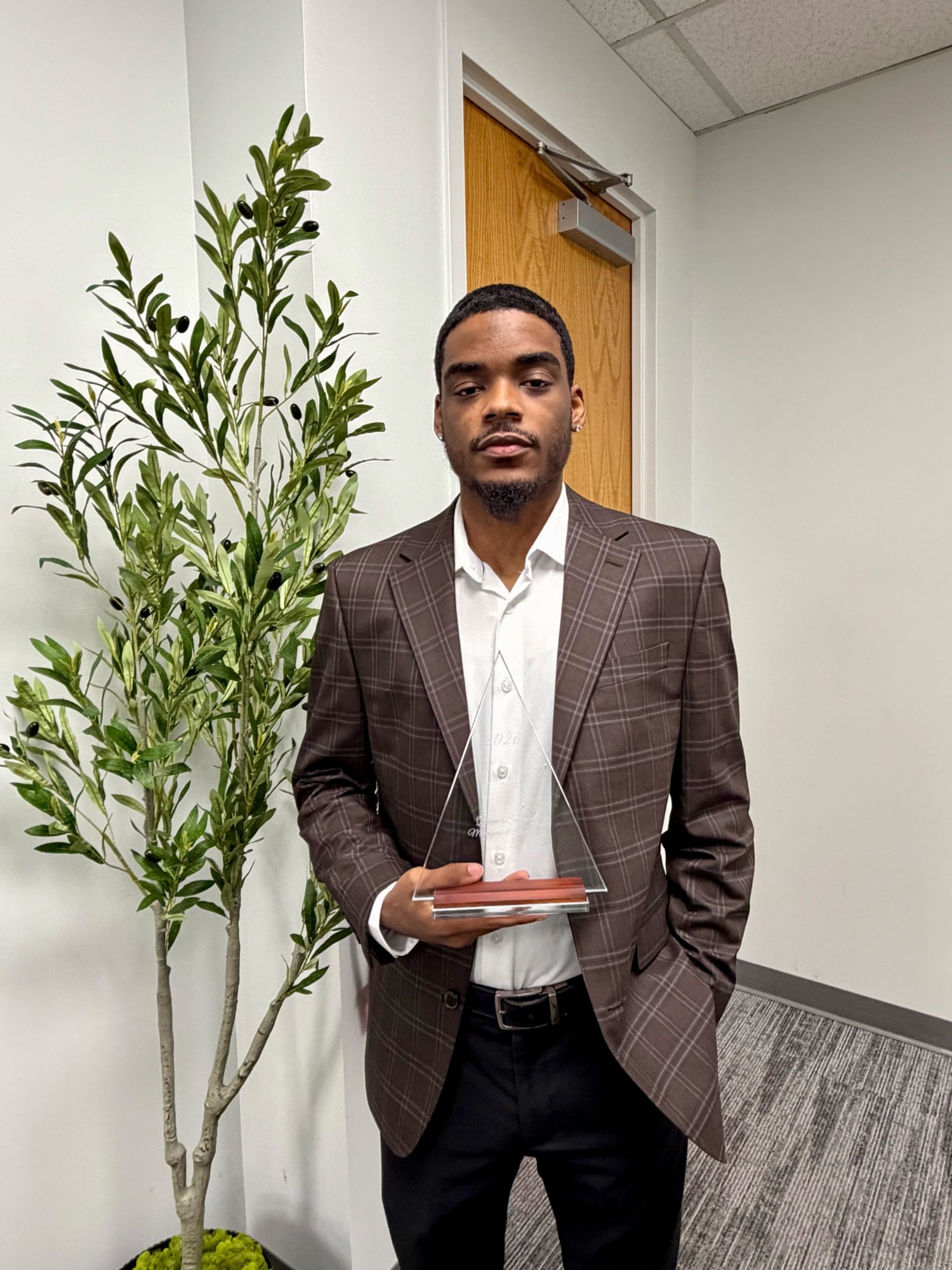 Fifth Leaf Strategies professional in a black suit posing confidently by a lake and corporate building