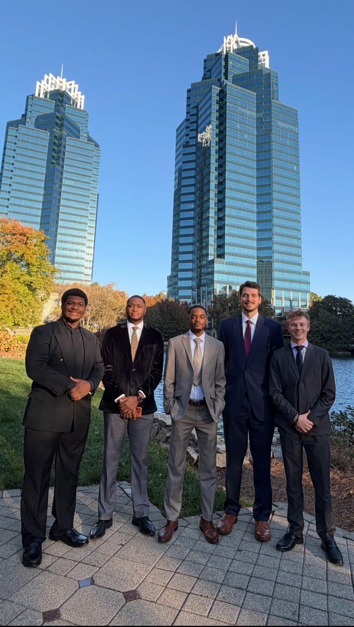 The Fifth Leaf Strategies team posed together in professional attire in front of skyscrapers
